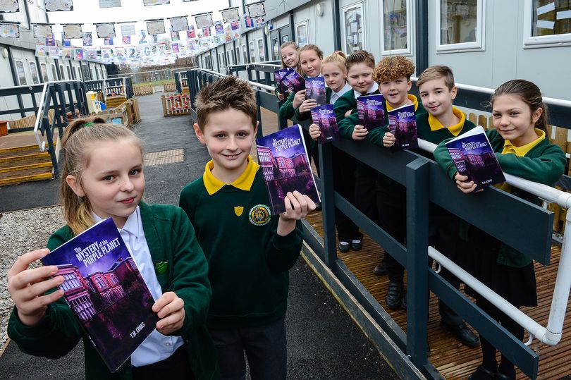 Children holding books and smiling